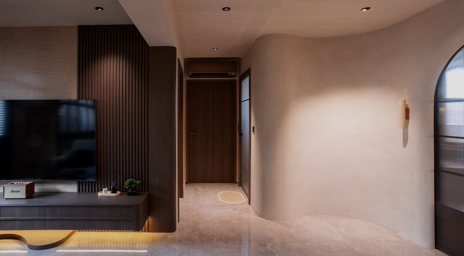 TV feature wall with dark timber slats and curved entry hallway