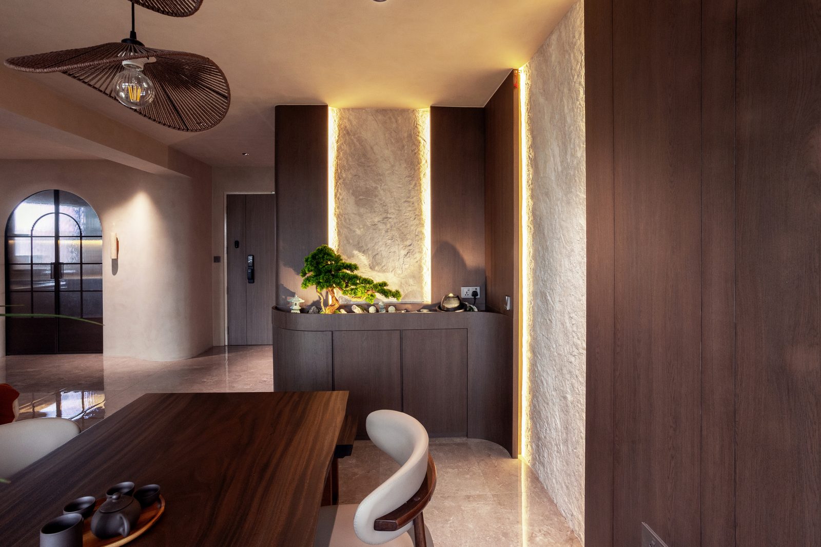 Dining nook with bonsai display cabinet and backlit stone feature