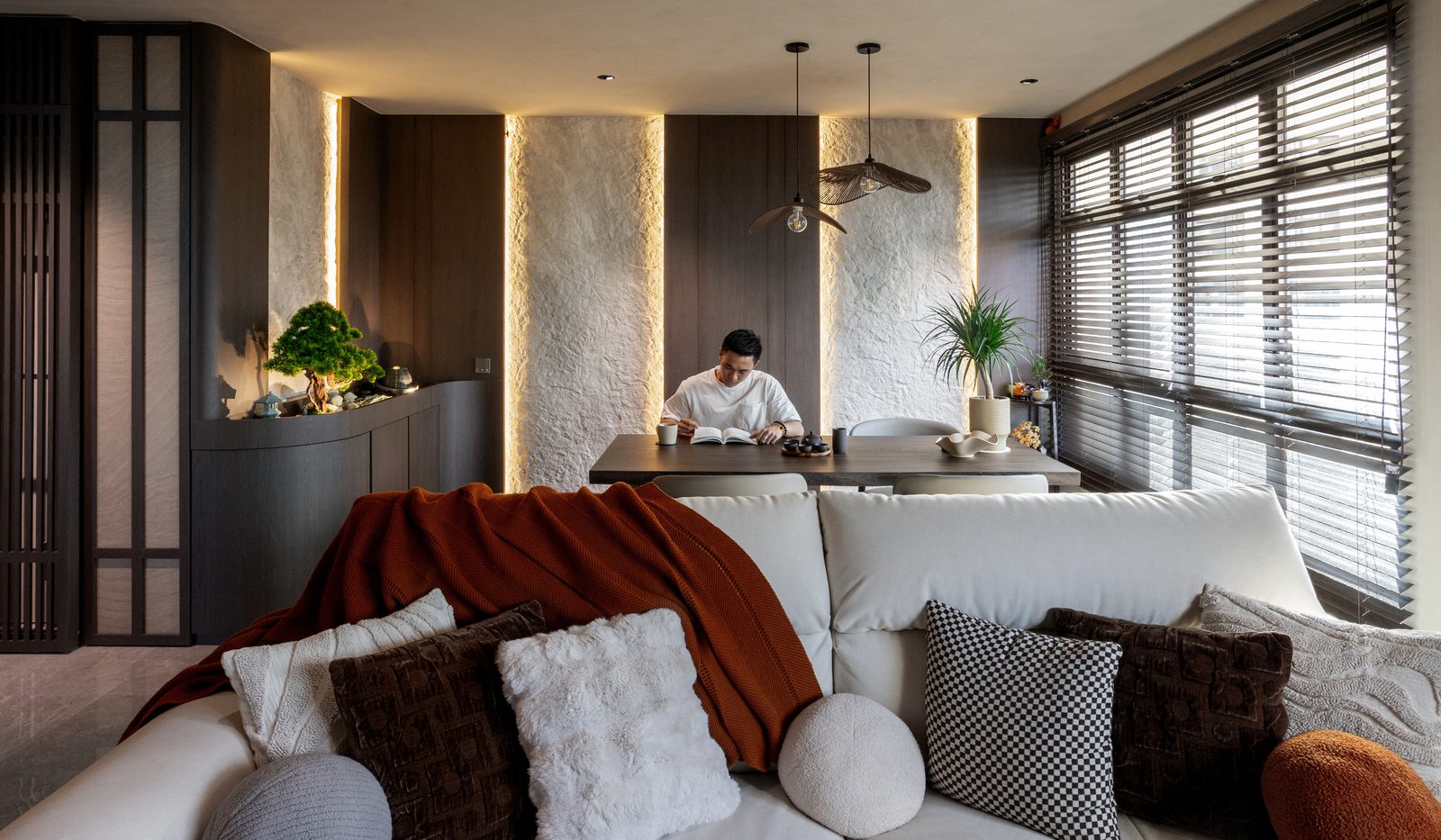 Living room overview with cloud sofa, Japanese art, and stone wall columns