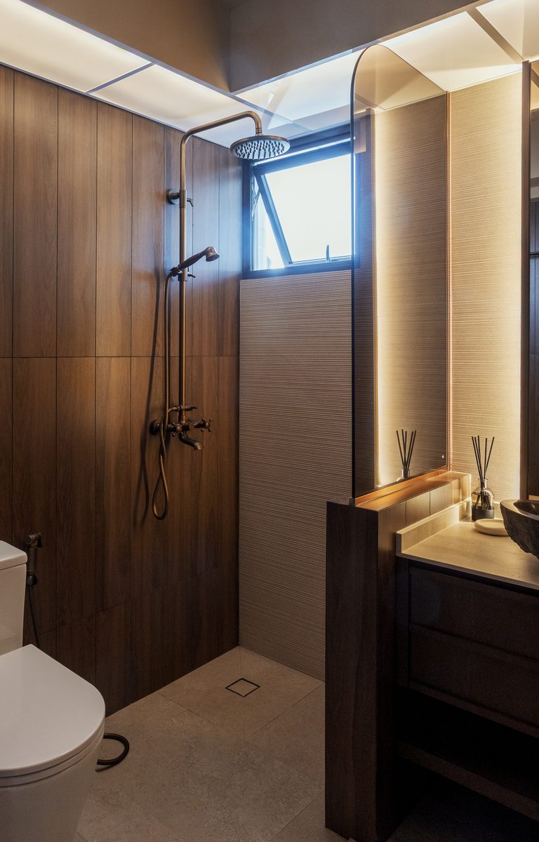 Master bathroom rain shower with aged brass fixtures and timber wall panels